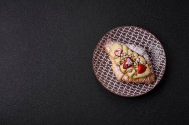 Kahvaltı için çikolatalı tatlı çilekli kruvasan. Fransız tatlısı, meyveli kruvasan.