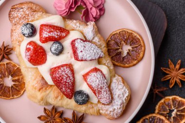 Kahvaltı için çikolatalı tatlı çilekli kruvasan. Fransız tatlısı, meyveli kruvasan.