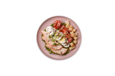 İçinde tavuk, parmesan peyniri, domates, kızarmış ekmek, marul yaprağı, keten tohumu, ayçiçeği ve susam tohumları olan bir kâse dolusu sezar salatası.