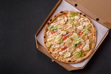 Peynirli ve tavuklu İtalyan sezar pizzası, marul yaprağı ve sos. Fast food, dilimlenmiş pizza.