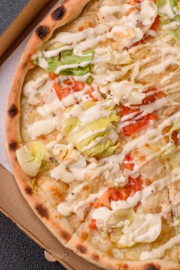 Peynirli ve tavuklu İtalyan sezar pizzası, marul yaprağı ve sos. Fast food, dilimlenmiş pizza.