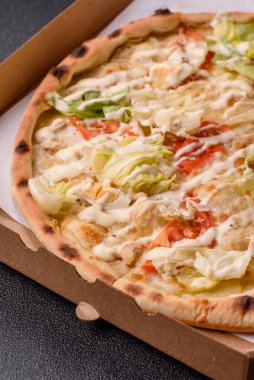 Peynirli ve tavuklu İtalyan sezar pizzası, marul yaprağı ve sos. Fast food, dilimlenmiş pizza.