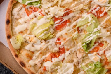 Peynirli ve tavuklu İtalyan sezar pizzası, marul yaprağı ve sos. Fast food, dilimlenmiş pizza.