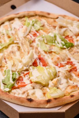 Peynirli ve tavuklu İtalyan sezar pizzası, marul yaprağı ve sos. Fast food, dilimlenmiş pizza.