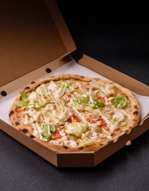 Peynirli ve tavuklu İtalyan sezar pizzası, marul yaprağı ve sos. Fast food, dilimlenmiş pizza.