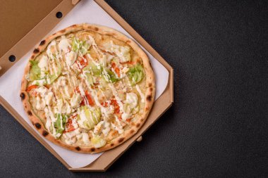 Peynirli ve tavuklu İtalyan sezar pizzası, marul yaprağı ve sos. Fast food, dilimlenmiş pizza.