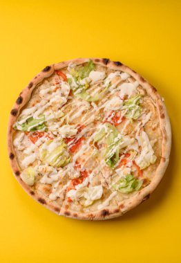 Peynirli ve tavuklu İtalyan sezar pizzası, marul yaprağı ve sos. Fast food, dilimlenmiş pizza.