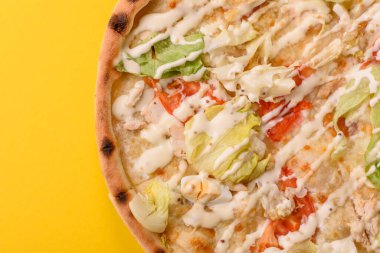 Peynirli ve tavuklu İtalyan sezar pizzası, marul yaprağı ve sos. Fast food, dilimlenmiş pizza.