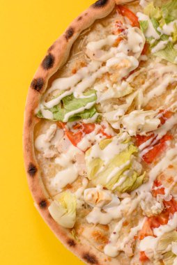 Peynirli ve tavuklu İtalyan sezar pizzası, marul yaprağı ve sos. Fast food, dilimlenmiş pizza.