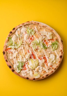Peynirli ve tavuklu İtalyan sezar pizzası, marul yaprağı ve sos. Fast food, dilimlenmiş pizza.