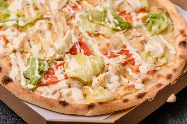 Peynirli ve tavuklu İtalyan sezar pizzası, marul yaprağı ve sos. Fast food, dilimlenmiş pizza.