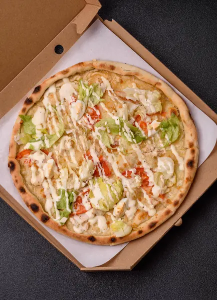 Peynirli ve tavuklu İtalyan sezar pizzası, marul yaprağı ve sos. Fast food, dilimlenmiş pizza.