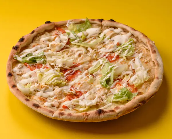 Peynirli ve tavuklu İtalyan sezar pizzası, marul yaprağı ve sos. Fast food, dilimlenmiş pizza.