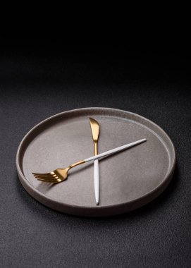 Boş tabak ve saat şeklinde cihazlar öğle yemeği molası, kahve molası, yemek molası için kavramsal bir arka plan olarak kullanılıyor.