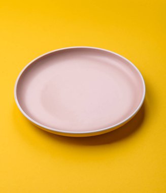 Sarı arka planda boş seramik tabak. Tasarımınız için gıda arkaplanı