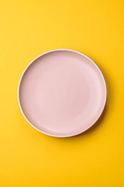 Sarı arka planda boş seramik tabak. Tasarımınız için gıda arkaplanı