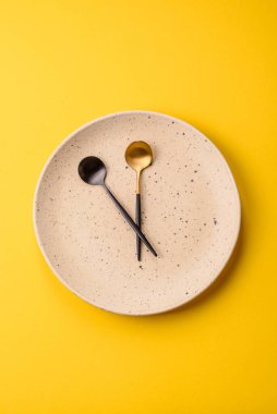 Boş tabak ve saat şeklinde cihazlar öğle yemeği molası, kahve molası, yemek molası için kavramsal bir arka plan olarak kullanılıyor.