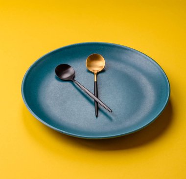 Boş tabak ve saat şeklinde cihazlar öğle yemeği molası, kahve molası, yemek molası için kavramsal bir arka plan olarak kullanılıyor.