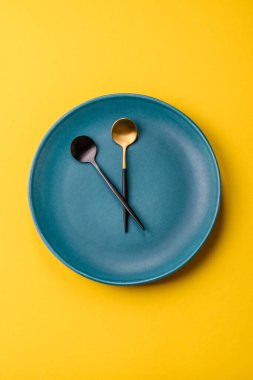 Boş tabak ve saat şeklinde cihazlar öğle yemeği molası, kahve molası, yemek molası için kavramsal bir arka plan olarak kullanılıyor.