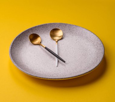 Boş tabak ve saat şeklinde cihazlar öğle yemeği molası, kahve molası, yemek molası için kavramsal bir arka plan olarak kullanılıyor.