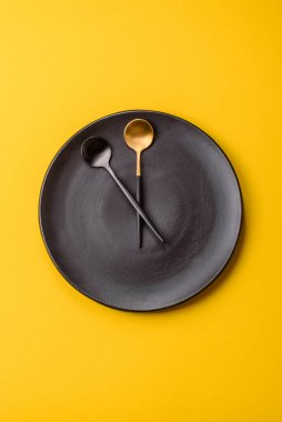 Boş tabak ve saat şeklinde cihazlar öğle yemeği molası, kahve molası, yemek molası için kavramsal bir arka plan olarak kullanılıyor.