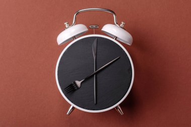 Boş tabak ve saat şeklinde cihazlar öğle yemeği molası, kahve molası, yemek molası için kavramsal bir arka plan olarak kullanılıyor.