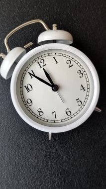 Ofis ve iş yerlerindeki son teslim tarihleri için kavramsal bir arkaplan olarak sarı yüzeyde klasik alarm saati