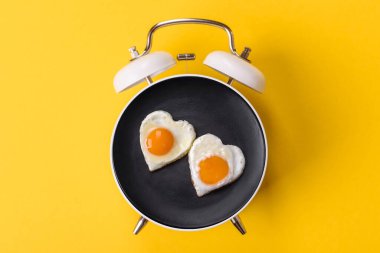 Pastırmalı, sosisli ve sebzeli sahanda yumurta. Kaliteli bir çalar saatin üzerindeki tabak şeklinde kahvaltı.