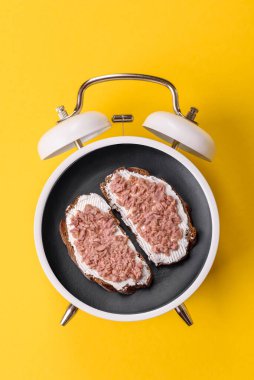 Tost, ton balığı ve avokado ile kahvaltı sandviçi. Kaliteli çalar saatin kadranı yerine tabak konsepti olarak kahvaltı.