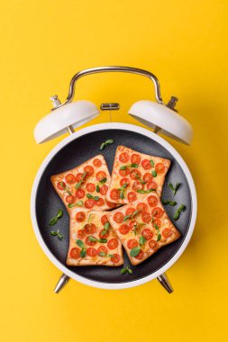 Tostlu sandviç, kiraz domatesleri, peynir, mikro yeşiller, tuz ve baharatlar. Kaliteli çalar saatin kadranı yerine tabak konsepti olarak kahvaltı.