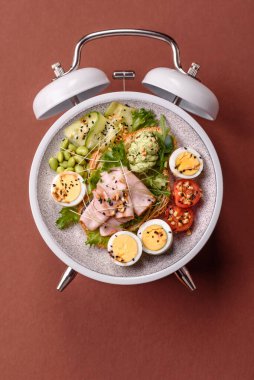 Tavuklu Sezar salatası, kızarmış ekmek, domates ve tohumlu yumurta. Kaliteli çalar saatin kadranı yerine tabak konsepti olarak kahvaltı.