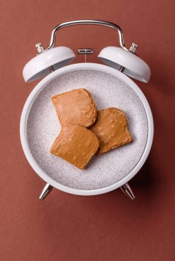 Tost ve fıstık ezmeli sandviç kahvaltısı. Kaliteli çalar saat yerine kahvaltı tabağı konsepti.