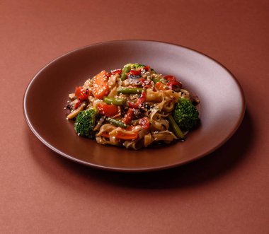 Çin ya da Tayland yemeği, etli, tuzlu ve baharatlı pirinç eriştesi. Arka plan olarak Asya yemekleri