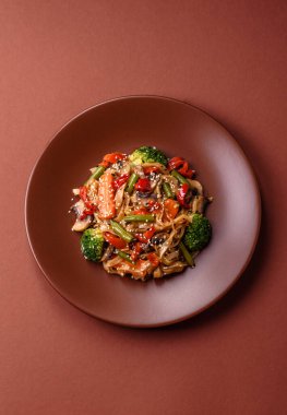 Çin ya da Tayland yemeği, etli, tuzlu ve baharatlı pirinç eriştesi. Arka plan olarak Asya yemekleri