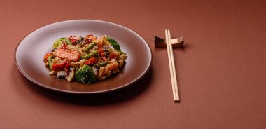 Çin ya da Tayland yemeği, etli, tuzlu ve baharatlı pirinç eriştesi. Arka plan olarak Asya yemekleri