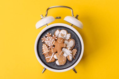 Noel, zencefilli çörek ya da klasik bir saatin üzerindeki bir tabakta bisküvi. Noel zamanı kavramsal arka plan, şenlikli tatlılar ve pastalar