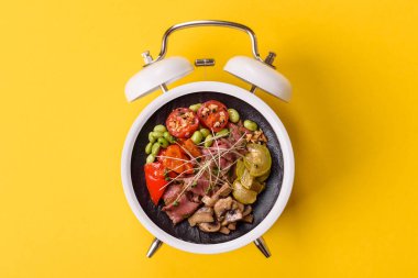 Tavuklu Sezar salatası, kızarmış ekmek, domates ve tohumlu yumurta. Kaliteli çalar saatin kadranı yerine tabak konsepti olarak kahvaltı.