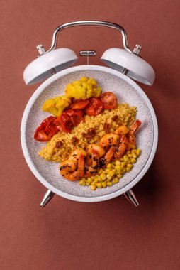 Çalar saatin arka planında kinoalı, sebzeli, etli ve yumurtalı vejetaryen salatası ya da kase. Vejetaryen yemeği yemek için kavramsal geçmiş zamanı