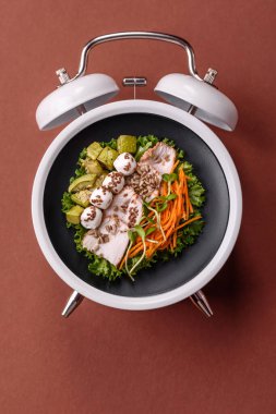 Tavuklu Sezar salatası, kızarmış ekmek, domates ve tohumlu yumurta. Kaliteli çalar saatin kadranı yerine tabak konsepti olarak kahvaltı.