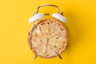 Dilimlenmiş İtalyan pizzası yeme ve restorandan teslim etme zamanı. Klasik bir çalar saatin tuşundaki pizza şeklindeki kavram.