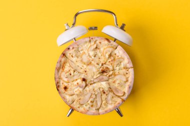 Dilimlenmiş İtalyan pizzası yeme ve restorandan teslim etme zamanı. Klasik bir çalar saatin tuşundaki pizza şeklindeki kavram.