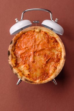 Dilimlenmiş İtalyan pizzası yeme ve restorandan teslim etme zamanı. Klasik bir çalar saatin tuşundaki pizza şeklindeki kavram.