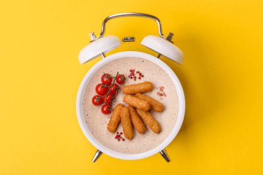 Peynir çubukları, kızarmış mozzarella, soslu fast food. Çalar saat skorbordunda tabakla fast food yeme zamanı.