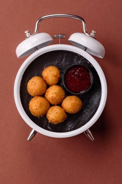 Peynirli toplar, kızarmış mozzarella kroketleri, soslu ekmek arası fast food. Çalar saat skorbordunda tabakla fast food yeme zamanı.