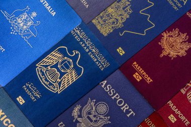 Farklı ülkelerin vatandaşlarının pasaportları, çeşitli ülkelerin pasaportlarından oluşan arka plan..