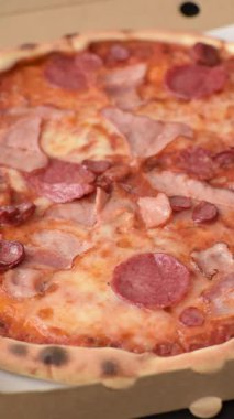 Peynirli ve salamlı İtalyan biberli pizza, domates ve sos. Fast food, dilimlenmiş pizza.