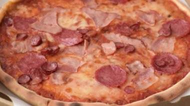 Peynirli ve salamlı İtalyan biberli pizza, domates ve sos. Fast food, dilimlenmiş pizza.