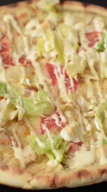 Peynirli ve tavuklu İtalyan sezar pizzası, marul yaprağı ve sos. Fast food, dilimlenmiş pizza.