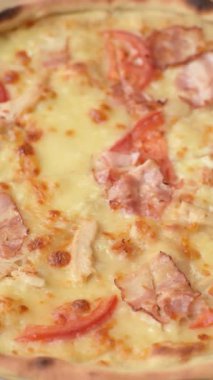 Tavuk ve pastırmalı İtalyan pizzası, peynir, domates ve sos. Fast food, dilimlenmiş pizza.