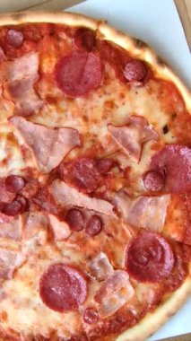 Peynirli ve salamlı İtalyan biberli pizza, domates ve sos. Fast food, dilimlenmiş pizza.